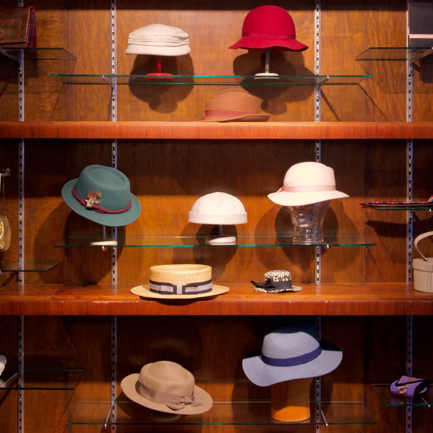 Ein schönes Holzregal bei Aventures de Paulette in Hamburg, präsentiert eine Vielzahl von bunten Hüten, entdecke individuelle Kopfbedeckungen für jeden Style.