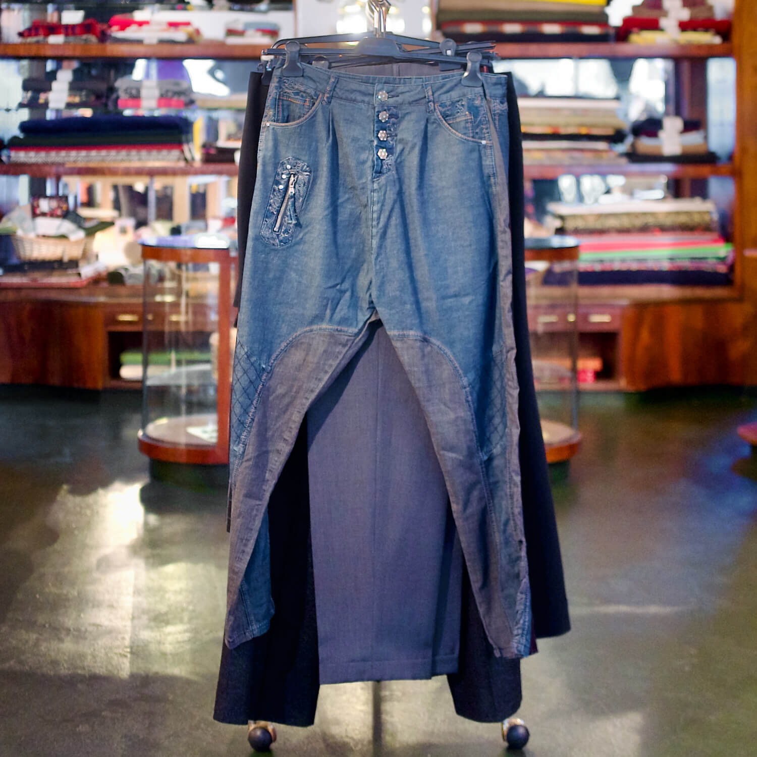 Eine Upcycling-Jeans auf einem Kleiderständer in der Innenansicht von Aventures de Paulette in Hamburg, entdecke nachhaltige und individuelle Fashion mit Stil.